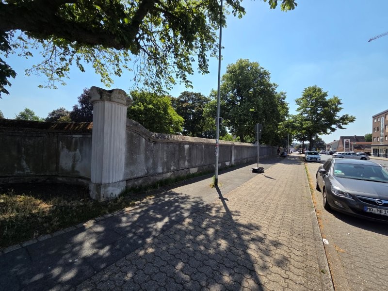 Zustand vor Arbeitsbeginn: Die Mauer entlang des Gehwegs zeigte starke Verfärbungen und Schäden an den starren Putzoberflächen.